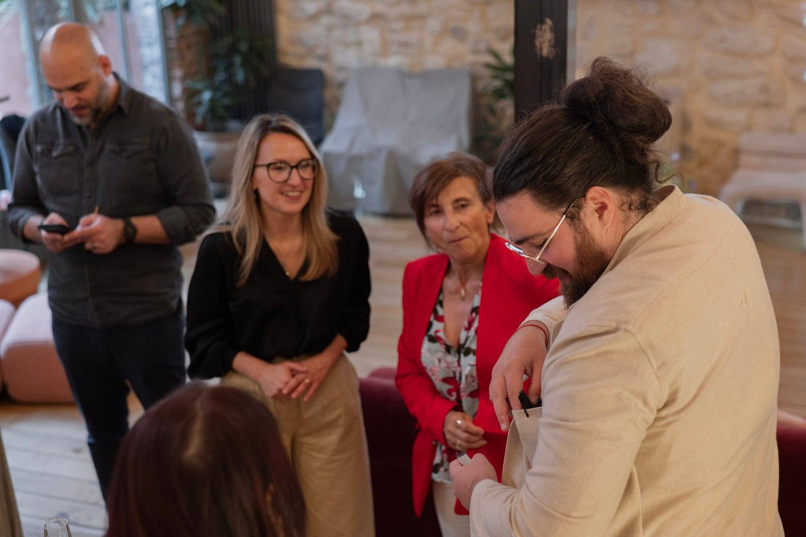 Pendant un cocktail d'entreprise, des invitées sourient autour d'un tour de close-up